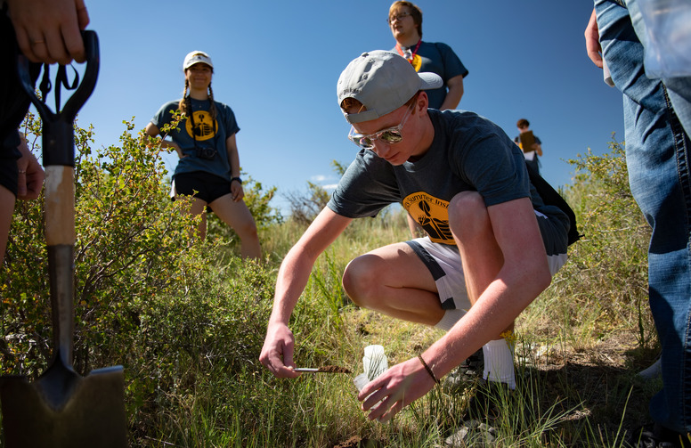 A group of students outside collecting soil samples