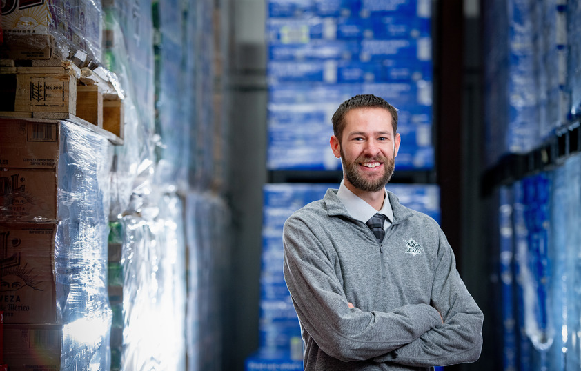 UW alum standing in front of beverage stock