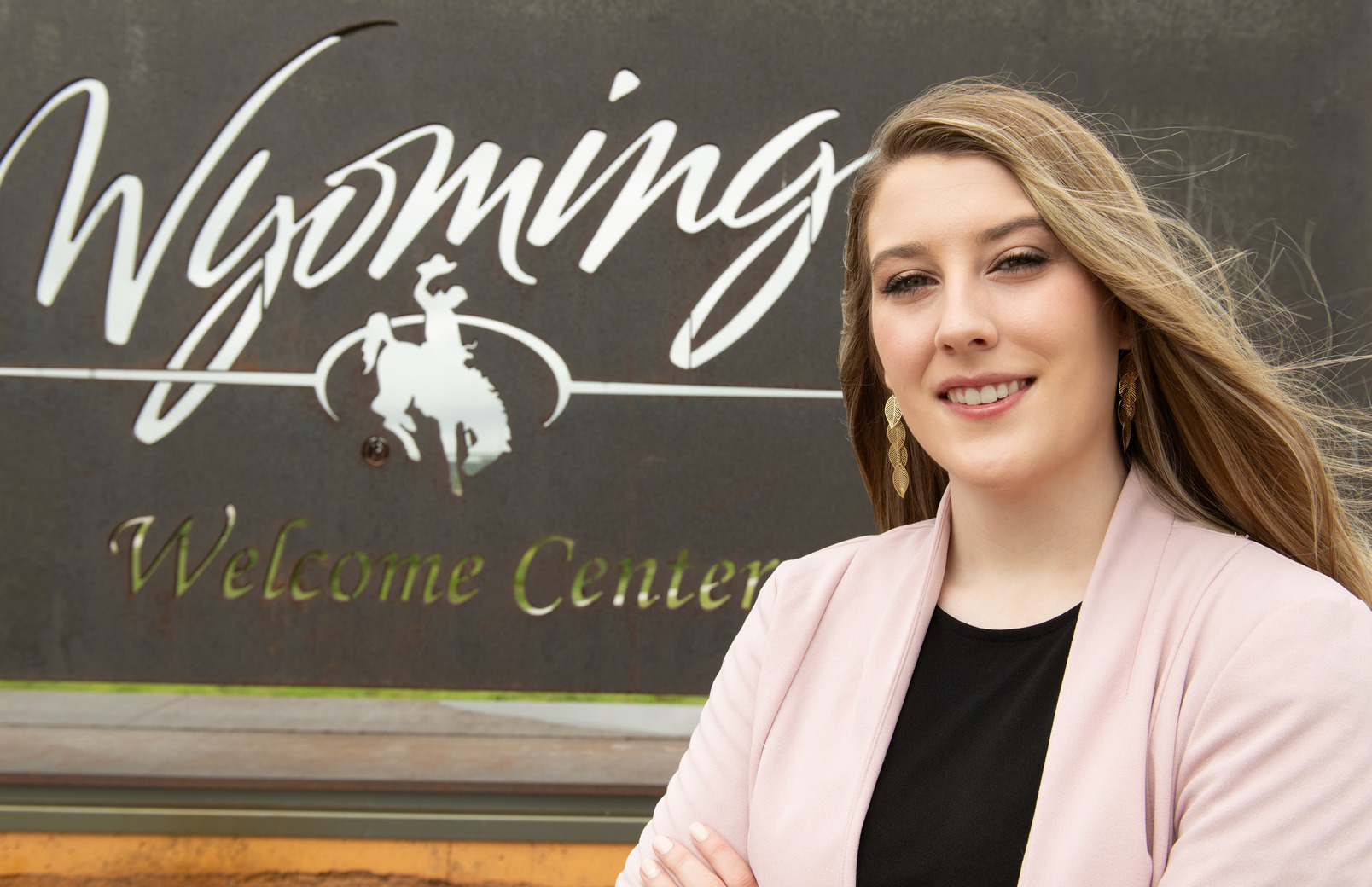 Alum standing in front of Wyoming Tourism sign