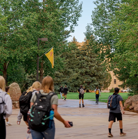 people with backpacks walking on a sidewalk