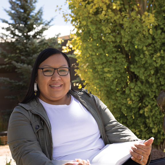 woman sitting outside with a book