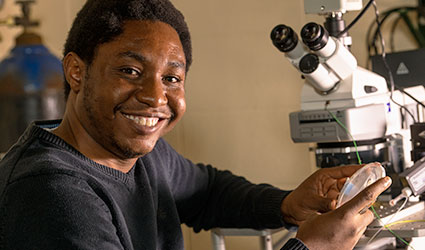 smiling person with microscope