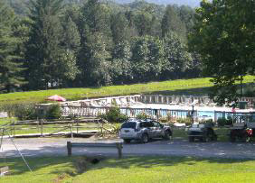 cars parked in parking lot by creek view