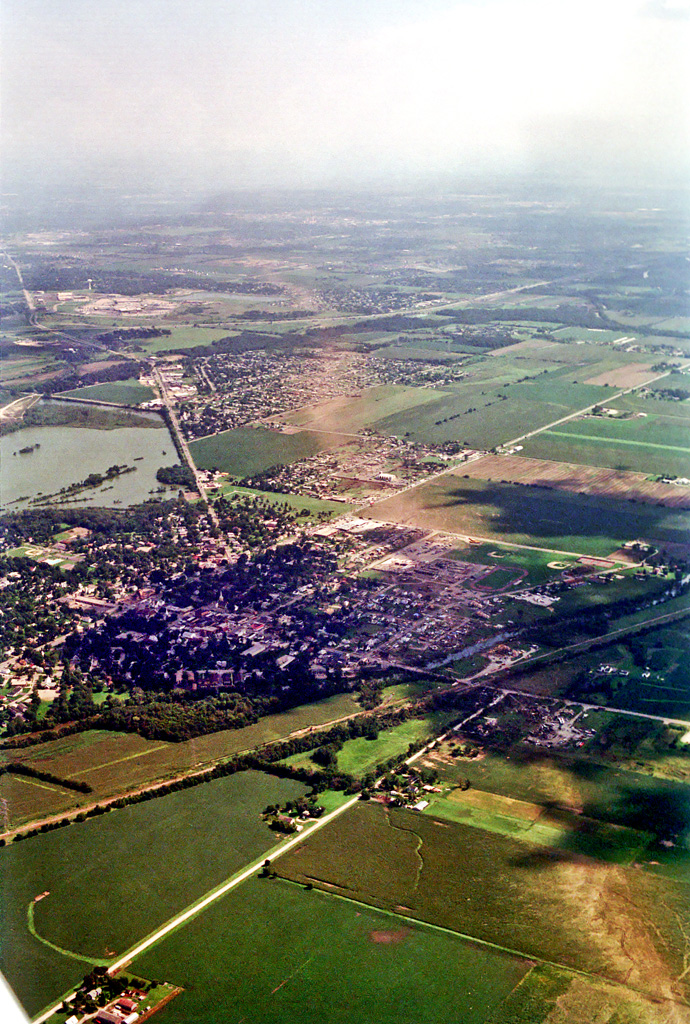 Photo showing damage path of 1990 Plainfield tornado from an airplane. Damage to buildings and vegetation is evident, which creates a clear path from near the foreground to the background. Photo vantage is from just northwest of Plainfield looking southeastward.