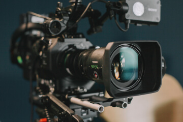 A film large camera stands against a blue backdrop